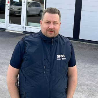 Tobias Karlsson standing outside SIGI Europe office in Norrköping, with company signage visible in background.
